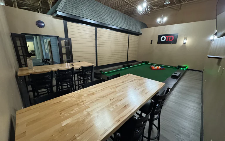 Wide view of the Footpool party room with tables, chairs and OTD wall sign