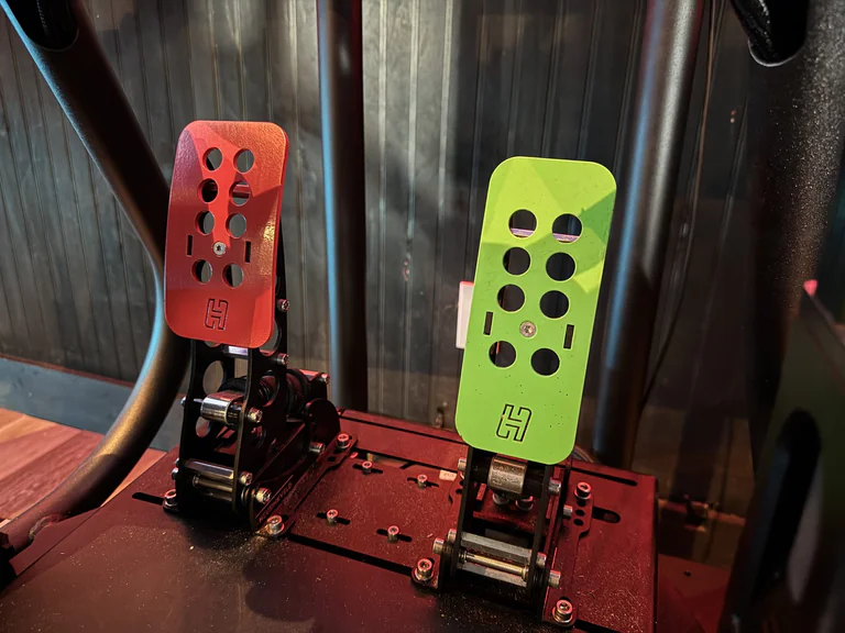 Red and green racing simulator pedal set mounted inside the SimGear cockpit