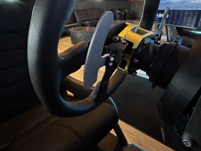 Close view of racing simulator wheel with paddle shifters and force feedback base