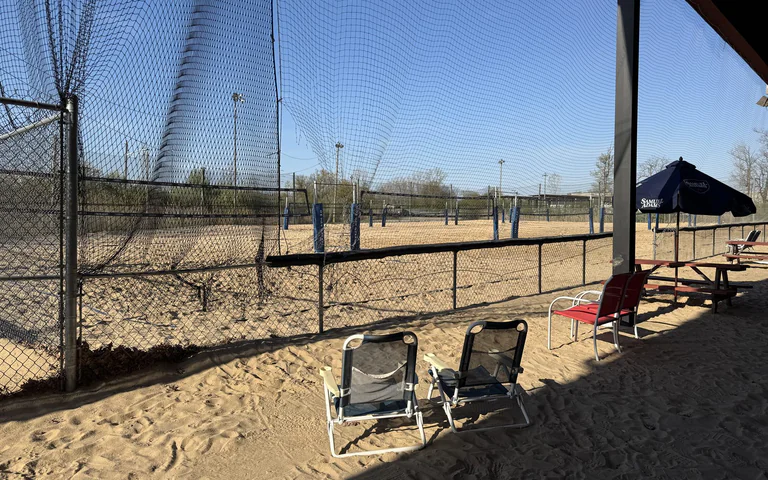 Sand volleyball courts and protective netting at On The Dunes Sports