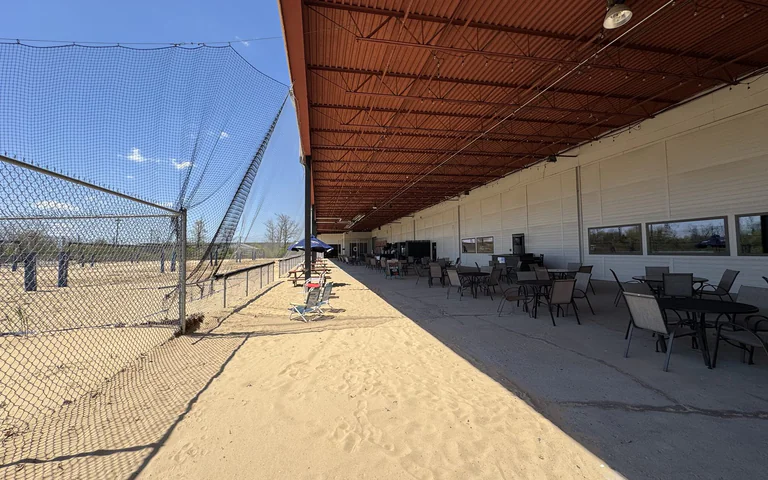 Long view of the volleyball courts and covered patio area at On The Dunes Sports