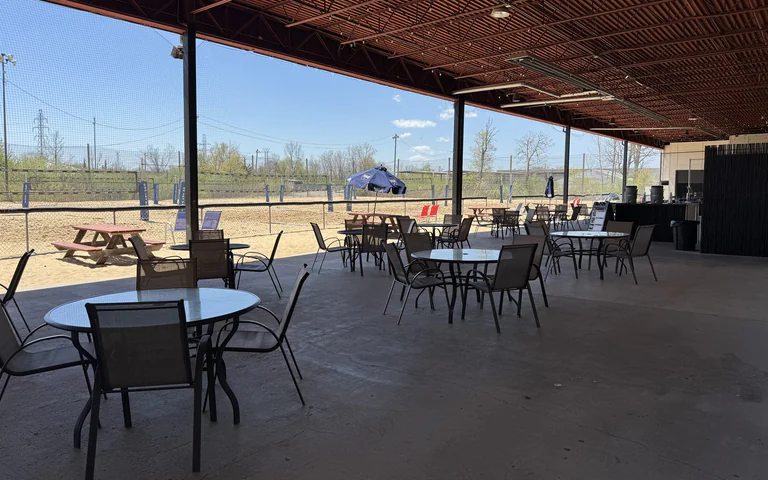 Covered patio seating beside the sand volleyball courts at On The Dunes Sports