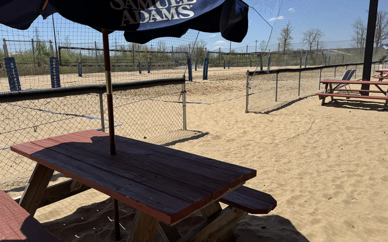 Picnic table seating next to the sand volleyball courts at On The Dunes Sports