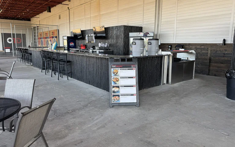 Angled view of the outdoor Tiki bar and service area at On The Dunes Sports