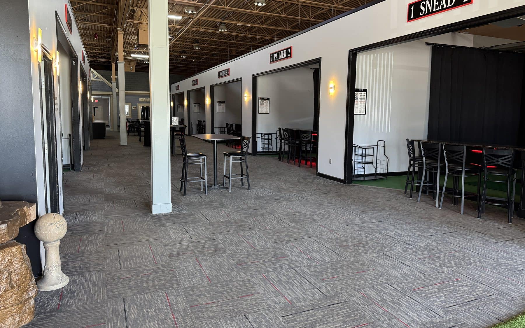Golf simulator bay corridor and practice area at On The Dunes Sports